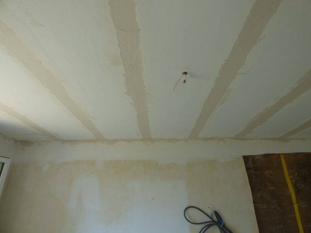 Grattage et rebouchage des poutrelles du plancher du premier étage suite à un défaut d’adhérence du plâtre.